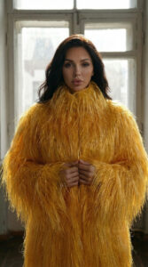 fashion model wearing golden feather coat standing