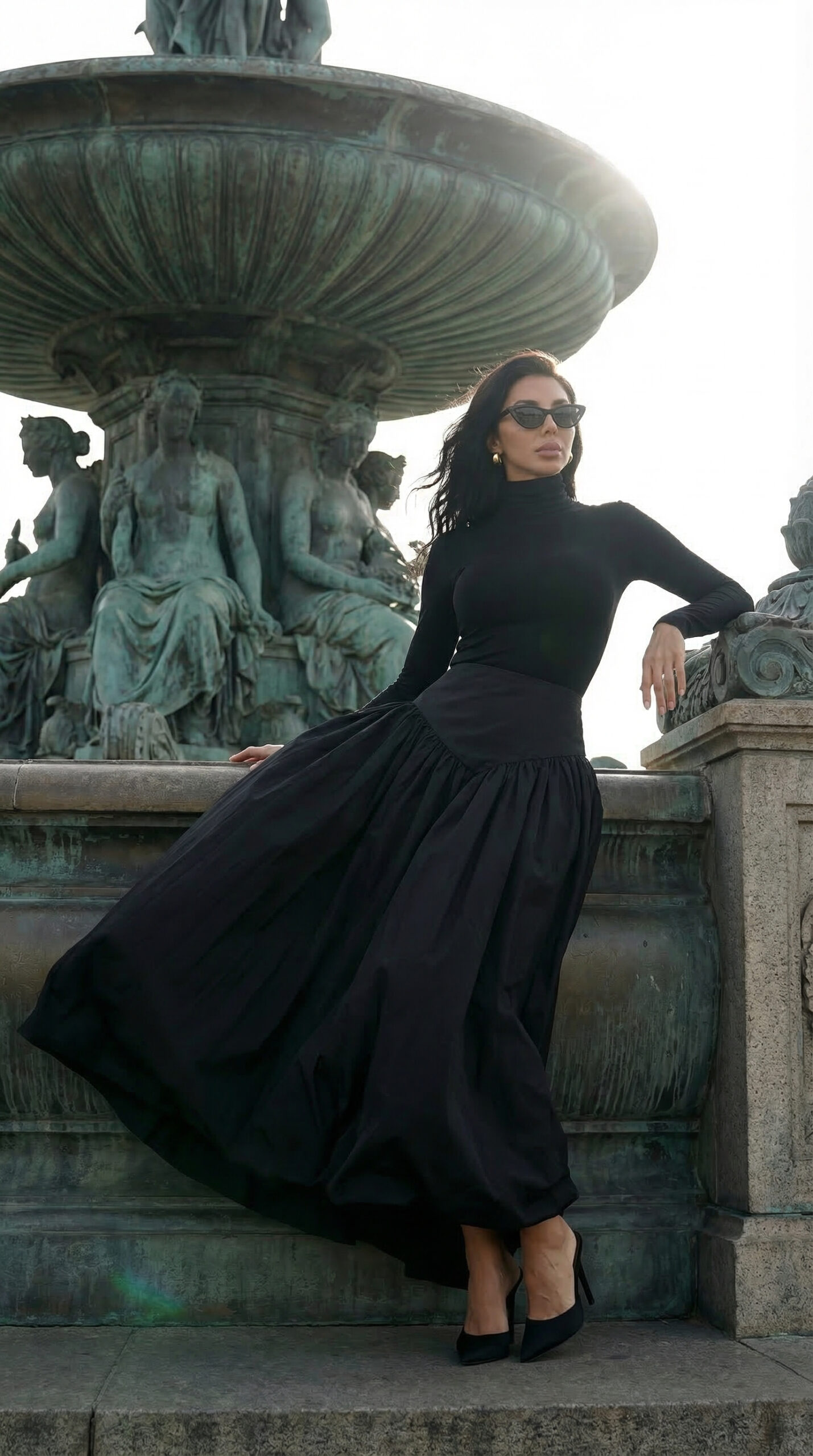 Fashion model in elegant black dress walking near Eiffel Tower in Paris editorial fashion photoshoot